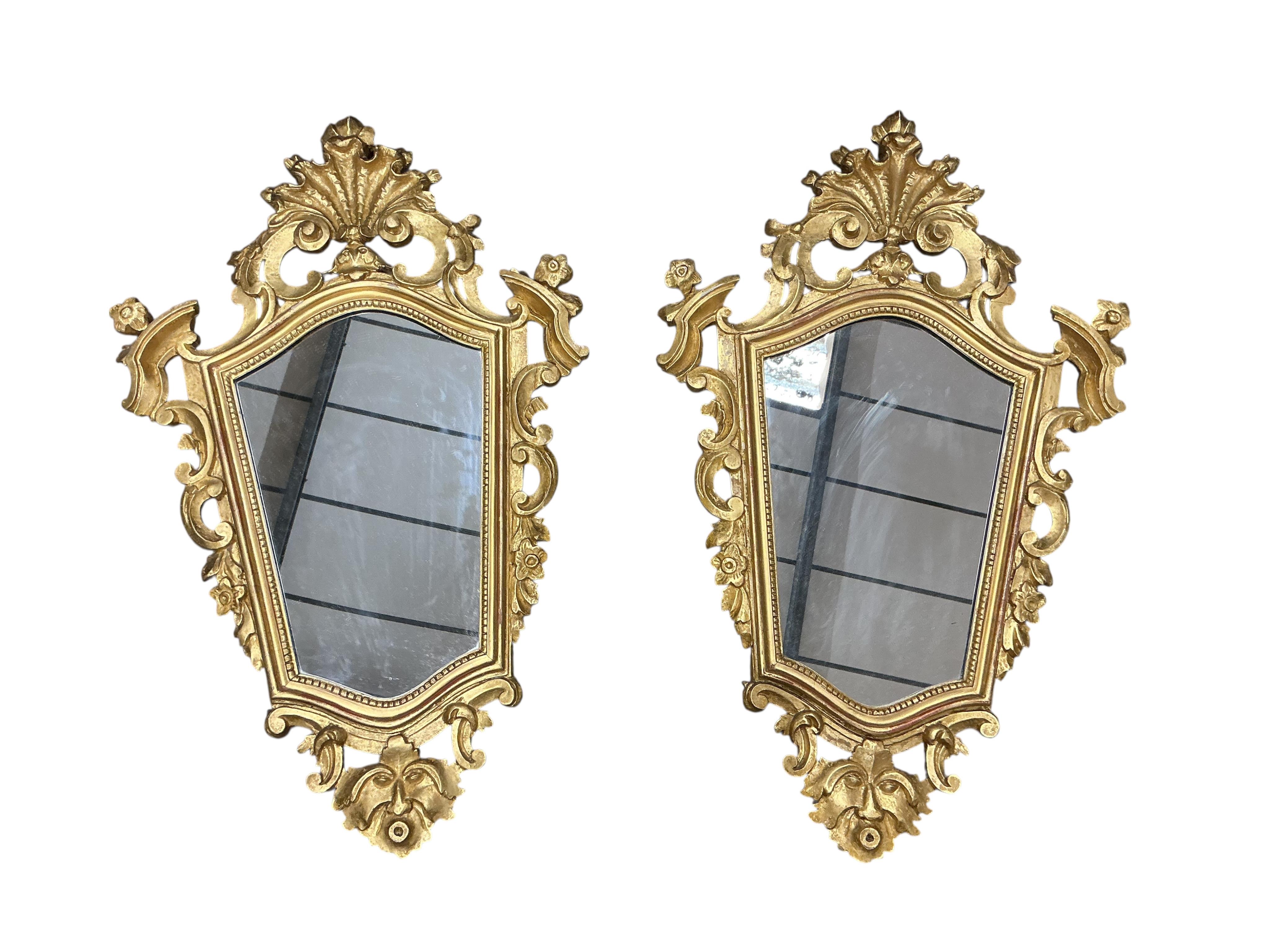 A pair of Continental carved giltwood cartouche shaped wall mirrors, width 48cm, height 77cm